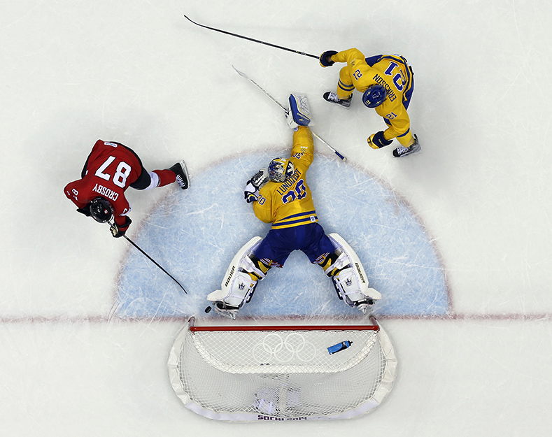 Sidney Crosby marque un but contre Henrik Lundqvist durant la deuxième période du match pour la médaille d'or aux Jeux olympiques de Sotchi. Le 23 février 2014. (AP Photo/David J. Phillip )