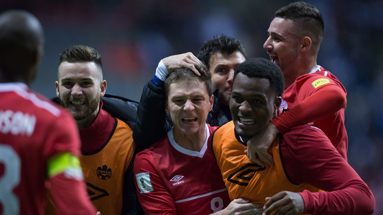 Cyle Larin (right in orange vest) is mobbed by teammates after Canada beat Honduras 1-0 on November 13, 2015 in FIFA World Cup qualifying. Larin scored the game's only goal. 