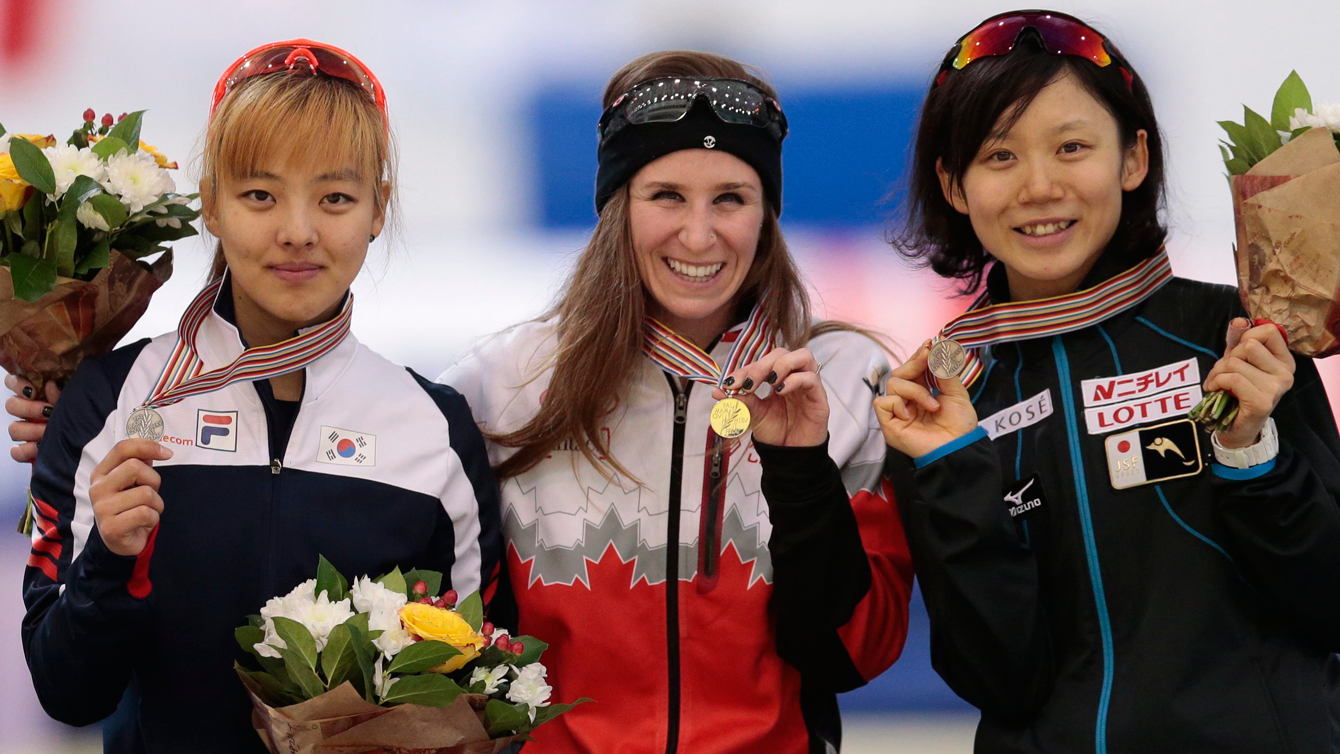 Ivanie Blondin (centre) holds up her mass start world championship gold medal on February 14, 2016 in Kolomna, Russia. 