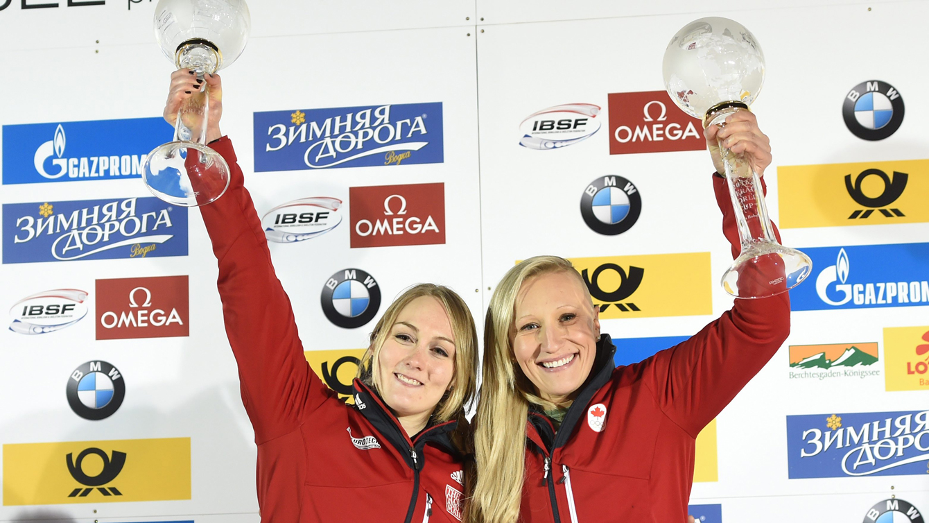 Kaillie Humphries et Melissa Lotholz tendent à bout de bras leur trophée après s'être emparées du titre global à Lake Koenigssee en Allemagne, le 26 février 2016.
