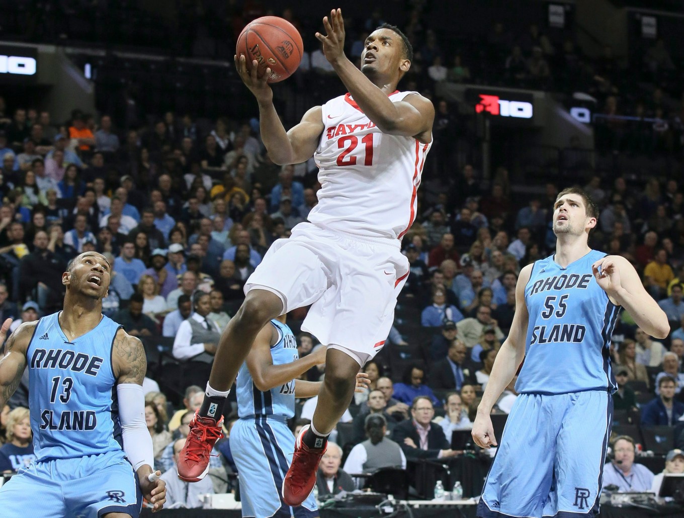 Dayton forward Dyshawn Pierre (21) shoots as Rhode Island guard T.J. Buchanan (13) and forward Gilvydas Biruta (55) look on during the first half of an NCAA college basketball game in the semifinals of the Atlantic 10 Conference tournament in New York, Saturday, March 14, 2015. (AP Photo/John Minchillo)