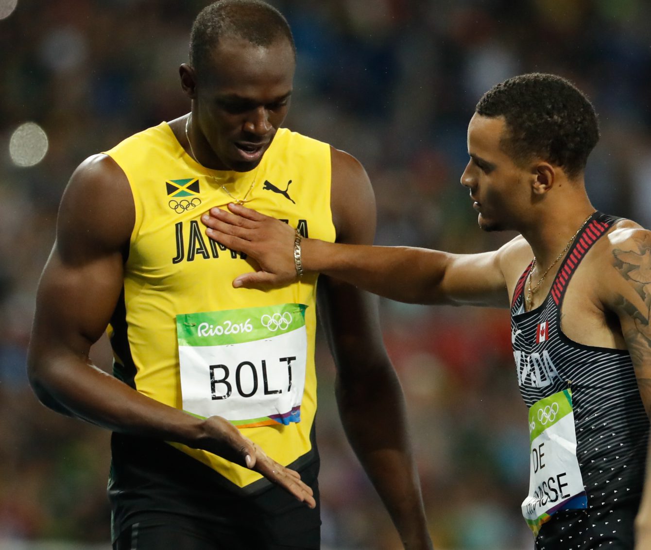 Andre De Grasse who finished second, congratulates Usain Bolt on his gold medal win in Rio on August 18, 2016. (photo/ Mark Blinch)