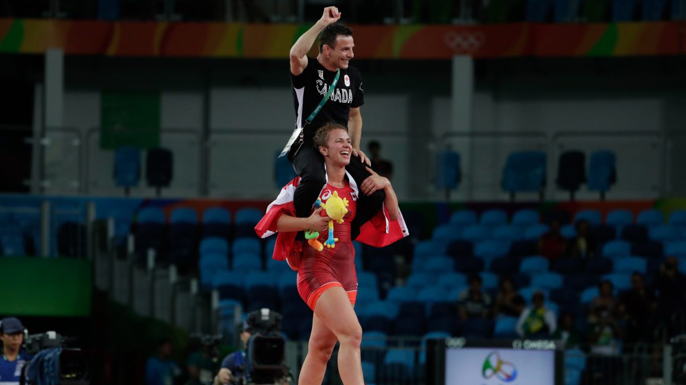 Erica Wiebe carries coach Paul Ragusa after after winning the gold medal during the women's 75-kg freestyle wrestling competition at the 2016 Summer Olympics in Rio de Janeiro, Brazil, Thursday, Aug. 18, 2016. photo/ Jason Ransom