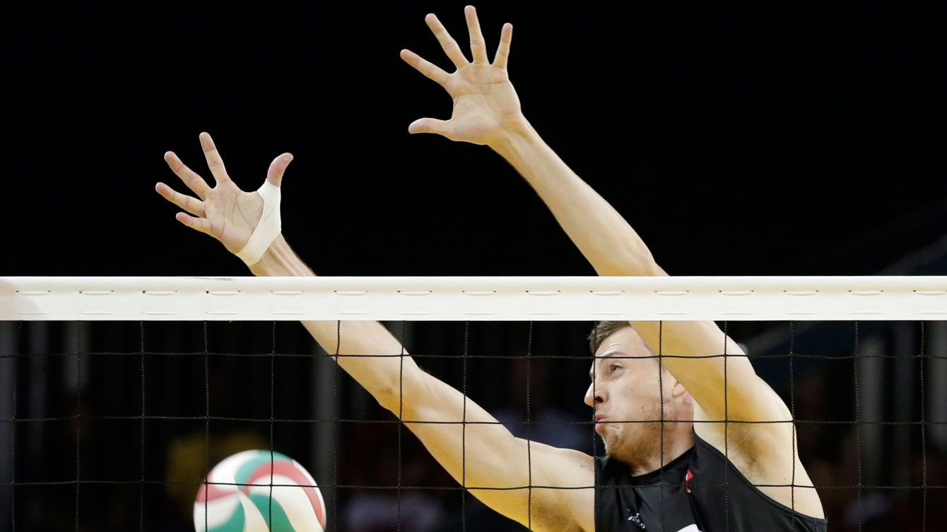 Canada's Graham Vigrass fails to block against Argentina during a men's volleyball semifinal match at the Pan Am Games in Toronto, Ontario, Friday, July 24, 2015. (AP Photo/Felipe Dana)