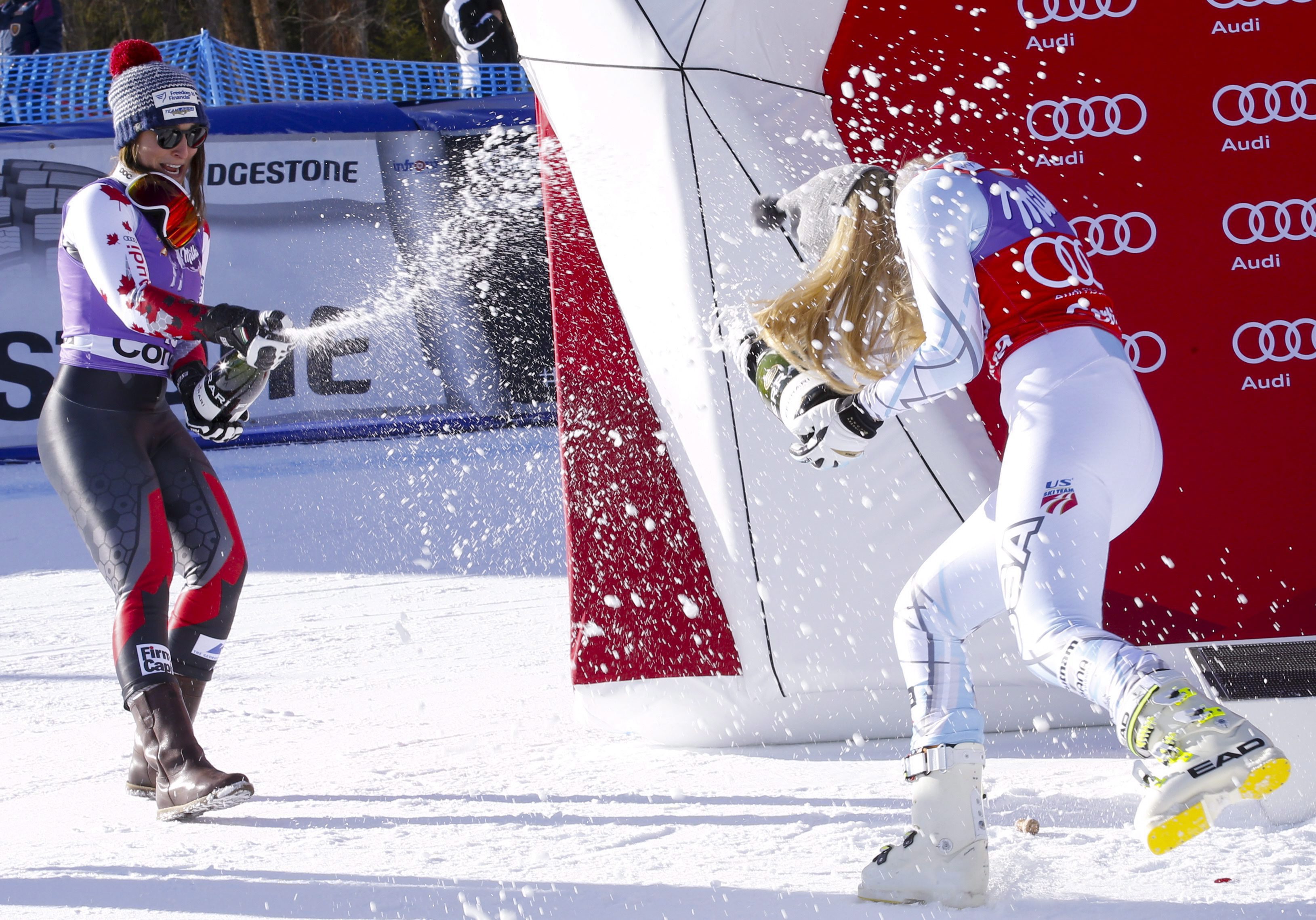 L'Américaine Lindsey Vonn (droite) et Larisa Yurkiw célèbrent après avoir pris respectivement les première et deuxièmes positions de l'épreuve de descente de la Coupe du monde de Cortina D'Ampezzo, en Italie, le 23 janvier 2016. (AP Photo/Armando Trovati)