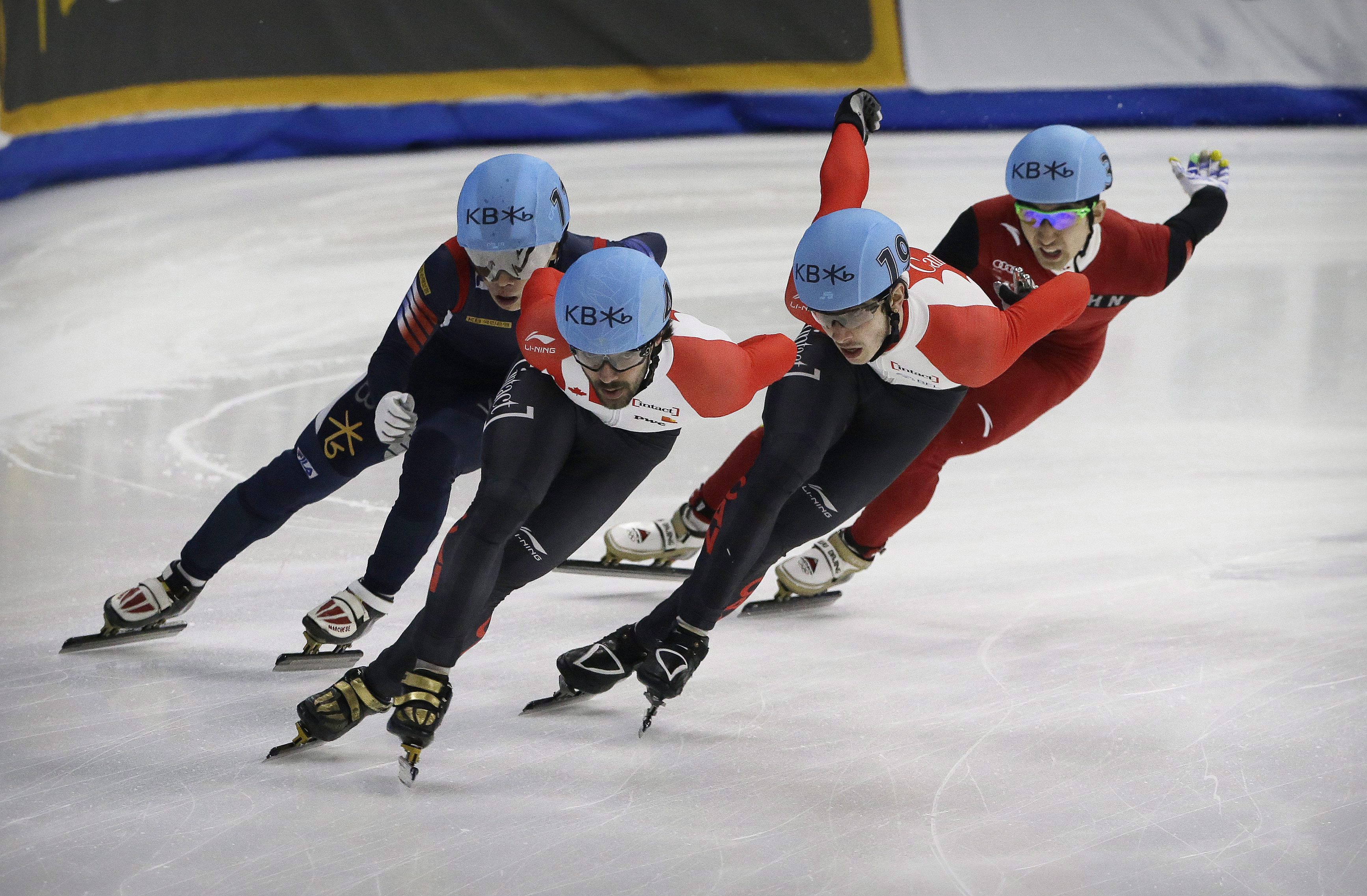 Charles Hamelin (2e à partir de la gauche) et Samuel Girard (2e à partir de la droite) lors des Championnats du monde de patinage de vitesse sur courte piste à Séoul, en Corée du Sud, le 13 mars 2016. (AP Photo/Ahn Young-joon)