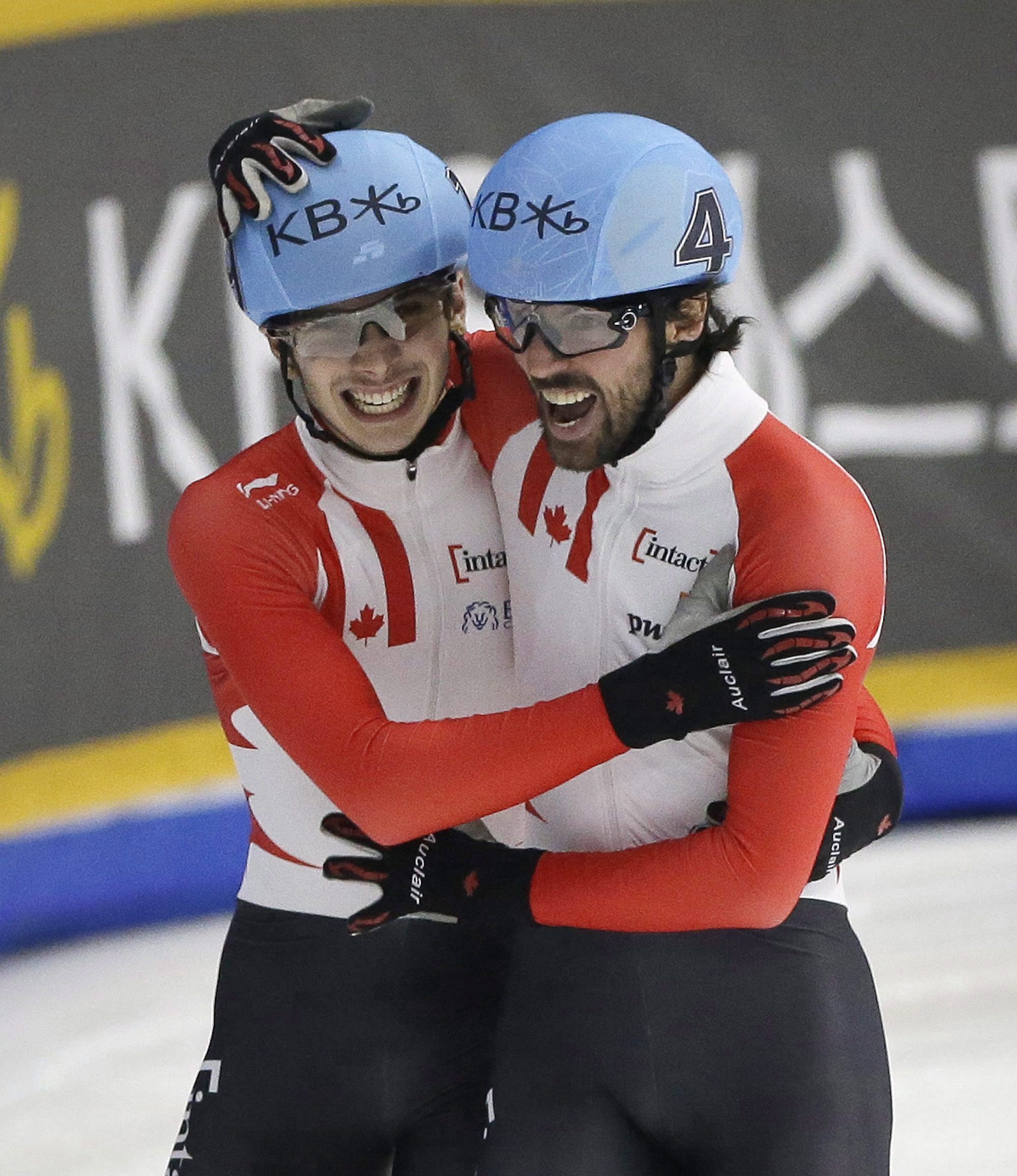 Charles Hamelin (droite) et Samuel Girard célèbrent après avoir remporté l'or et l'argent respectivement à l'épreuve 1000 m des Mondiaux de courte piste disputés à Séoul, en Corée du Sud, le 13 mars 2016. (AP Photo/Ahn Young-joon)