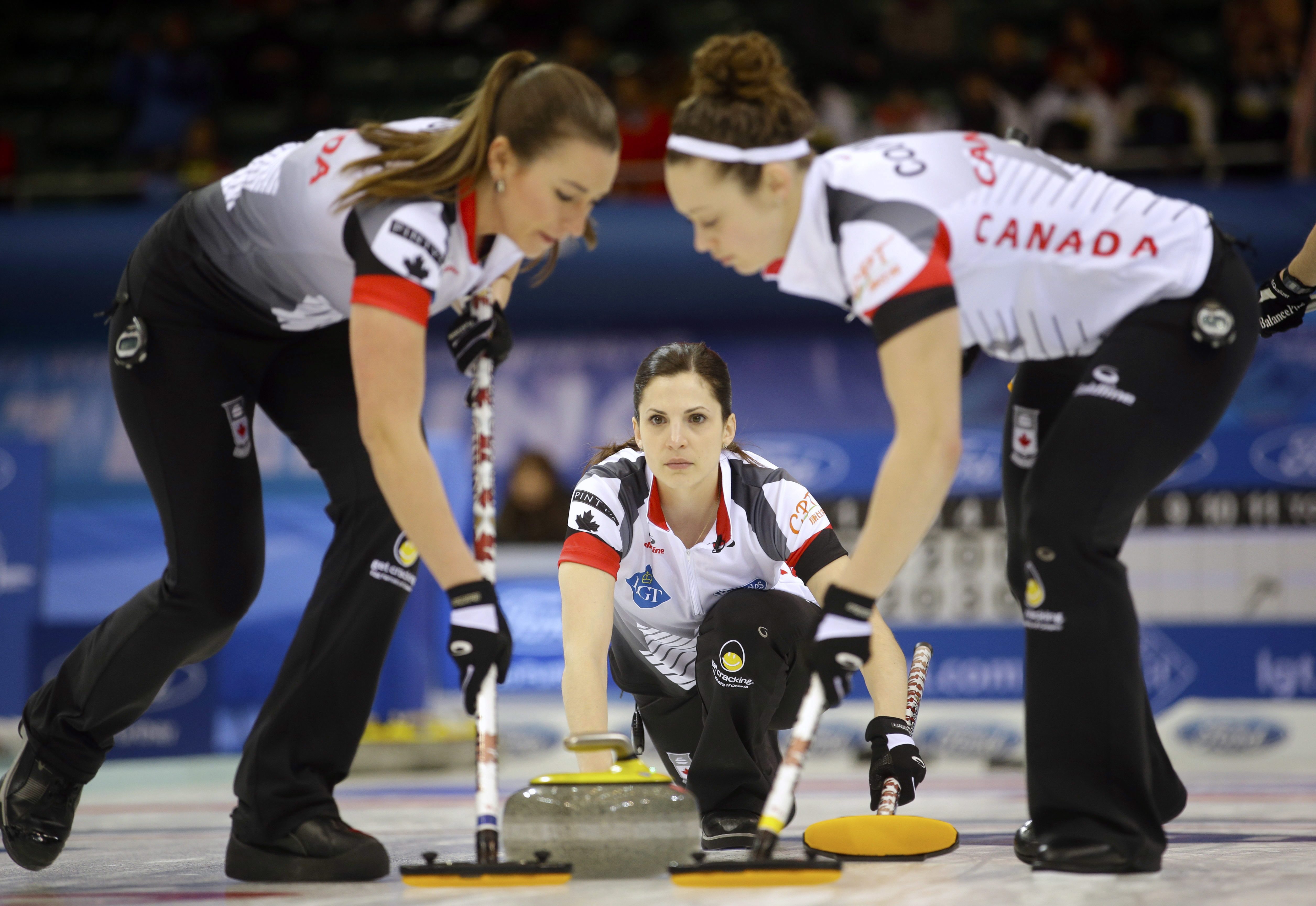 La Canadienne Lisa Weagle (centre) observe ses coéquipières Emma Miskew (gauche) et Joanne Courtney à l'oeuvre face à l'Italie au Championnat du monde de curling féminin, le 23 mars 2017. (AP Photo/Mark Schiefelbein)