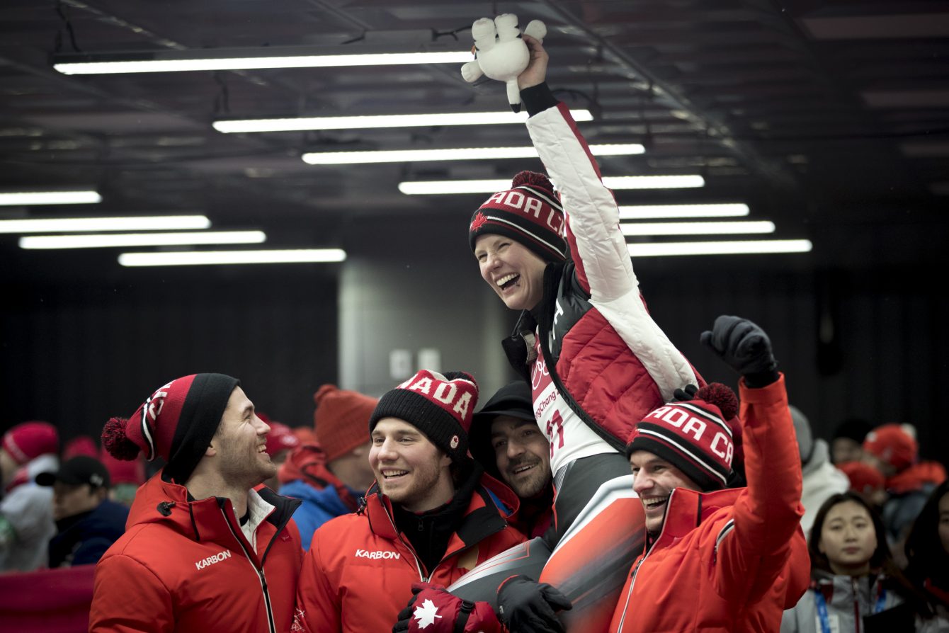 Alex Gough soulevée par ses coéquipiers après avoir remporté le bronze à l'épreuve individuelle de luge au Centre de glisse d'Alpensia, à Pyeongchang, en Corée du Sud, le mardi 13 février 2018. C'est la première médaille de l'histoire du Canada en luge. Photo : David Jackson
