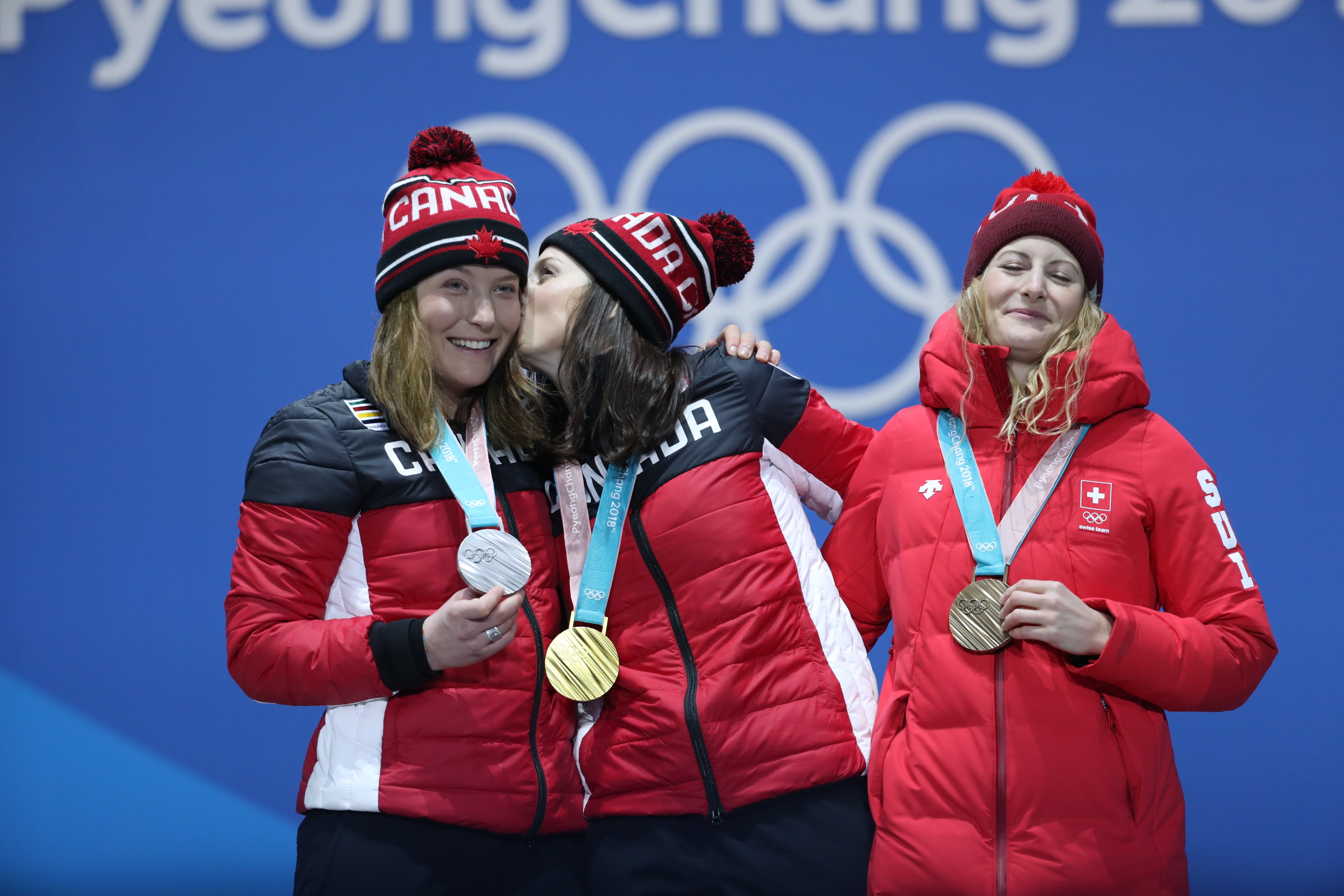 Les Canadiennes Kelsey Serwa et Brittany Phelan célèbrent leurs médailles d'or et d'argent lors de la cérémonie de remise des médailles aux Jeux olympiques d'hiver de PyeongChang 2018, en Corée du Sud, le vendredi 23 février 2018. Également sur la photo, la médaillée de bronze Fanny Smith, de la Suisse. (LA PRESSE CANADIENNE/HO - COC Ð David Jackson)